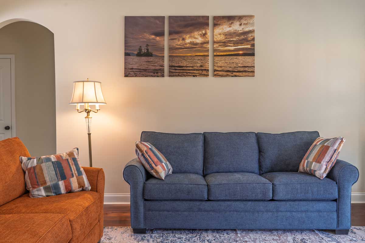 Upravená sedačka s polštáři tvoří hlavní vizuální bod obývacího pokoje.