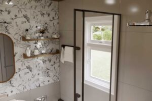 Koupelna v tiny house se sprchovým koutem a dekorativním obkladem s rostlinným motivem.