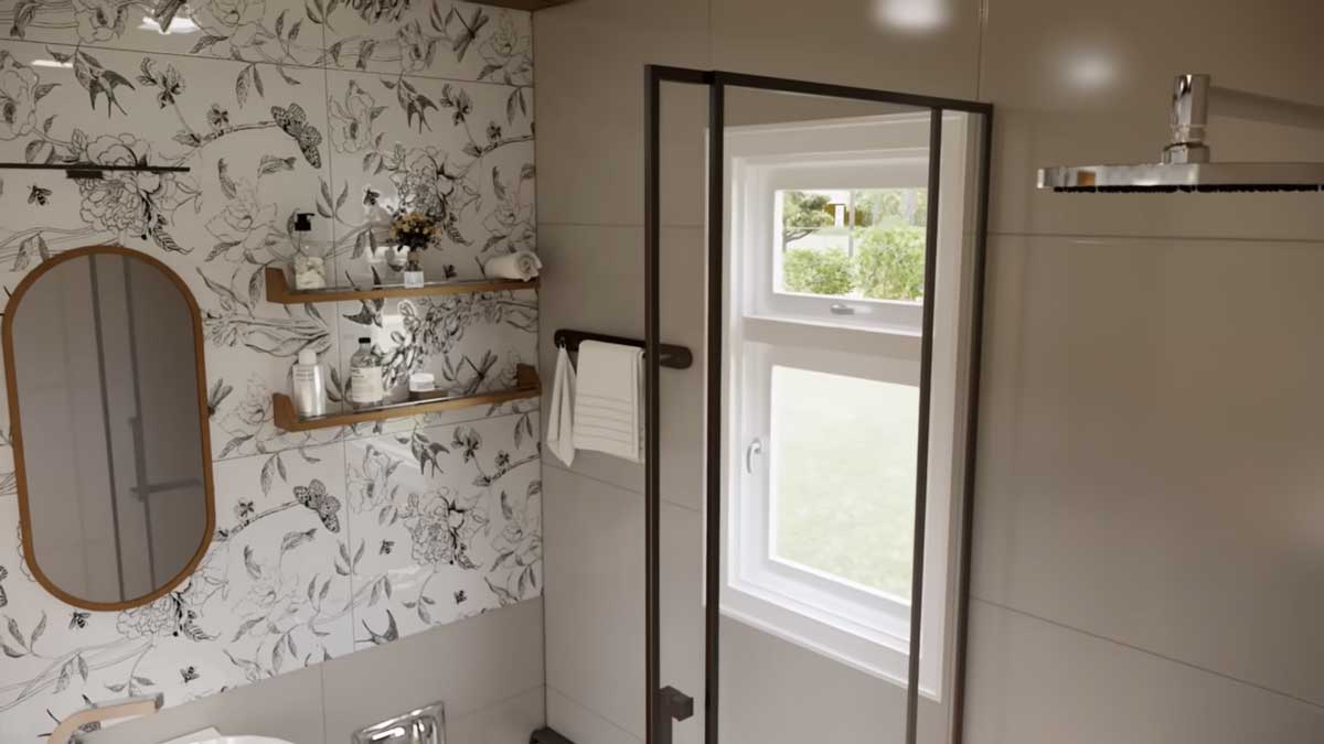 Koupelna v tiny house se sprchovým koutem a dekorativním obkladem s rostlinným motivem.