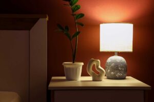 Stolní lampa s teplým světlem vytváří příjemnou atmosféru a zlepšuje funkčnost prostoru.