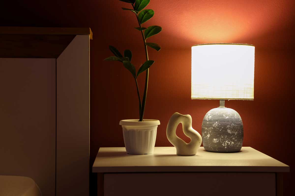 Stolní lampa s teplým světlem vytváří příjemnou atmosféru a zlepšuje funkčnost prostoru.