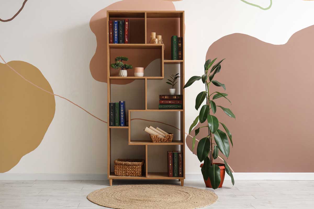Dřevěná otevřená police s knihami a dekoracemi ukazuje praktické a kvalitní úložné řešení do interiéru.