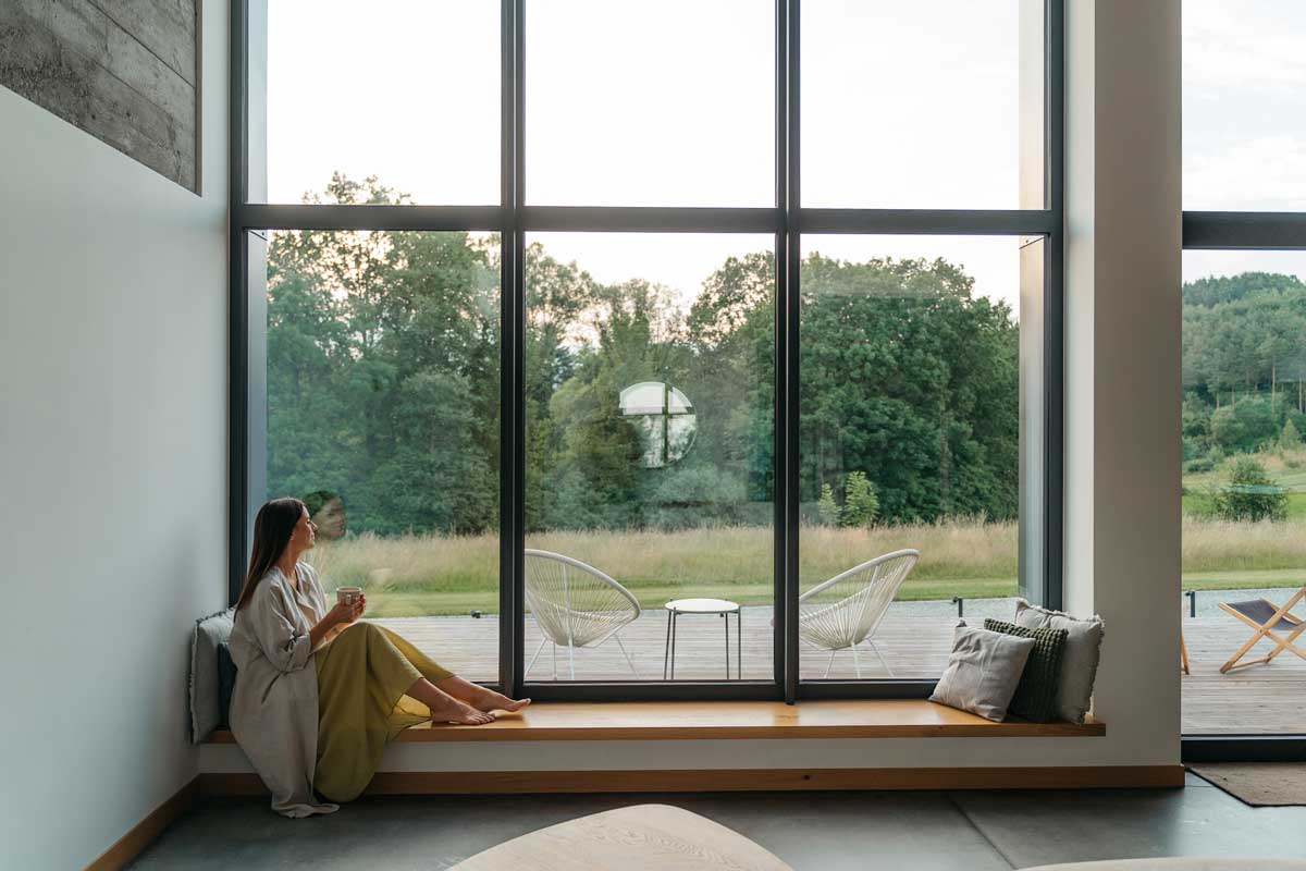 Velkoformátová okna v moderním interiéru umožňující výhled do zahrady a maximální přísun denního světla.