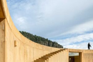 Betonové schodiště vedoucí po obloukové stěně domu směrem na střechu.