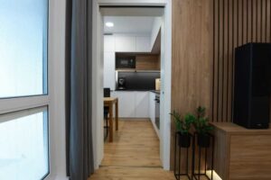 Pohled z obývacího prostoru do kuchyně ukazuje propojení místností a jednotný design celého bytu.