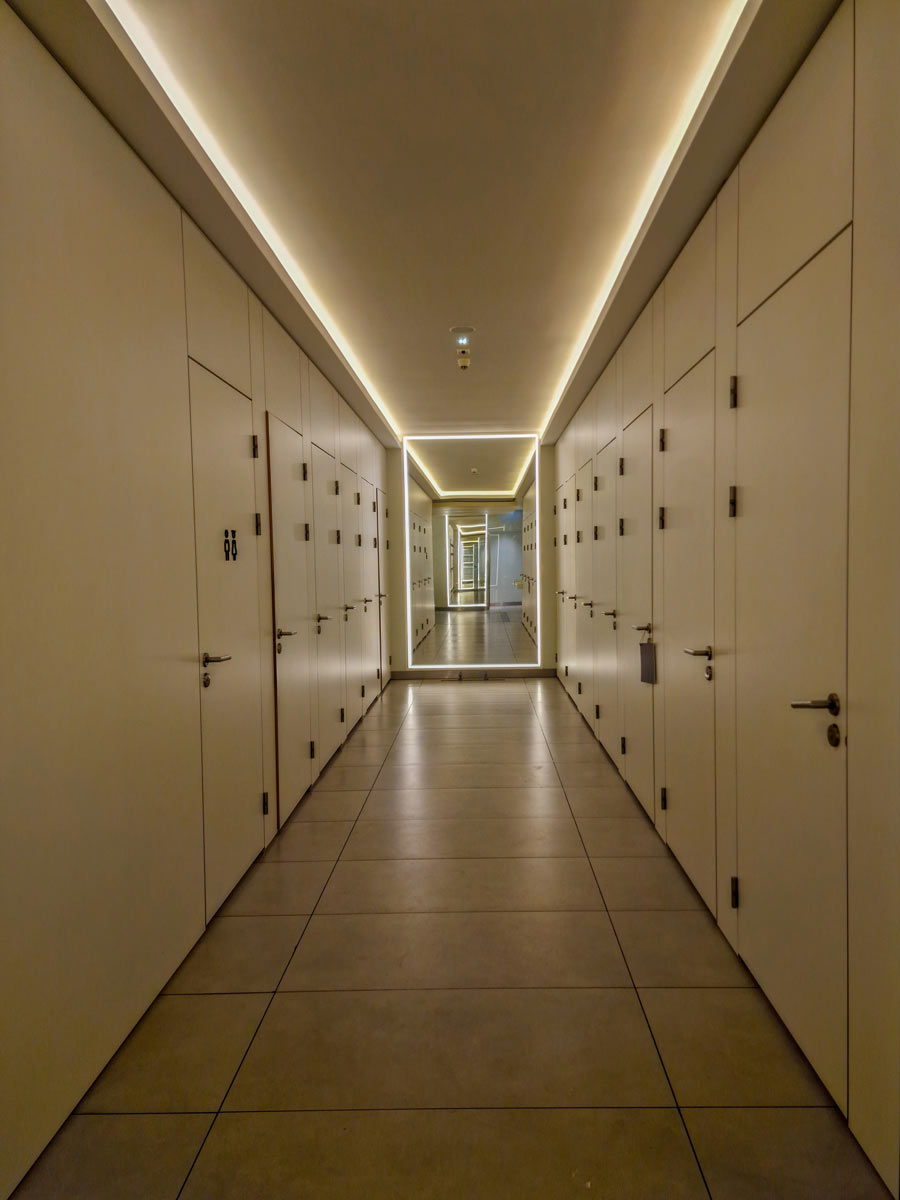 Úzká dlouhá chodba zakončená velkým zrcadlem vytváří silný tunelový a nekonečný efekt.