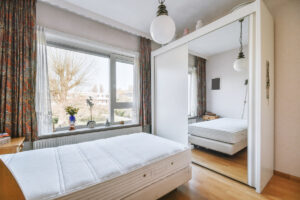 Ložnice s velkou šatní skříní a zrcadlovými dveřmi odráží postel i celé spací místo.