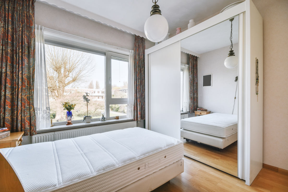 Ložnice s velkou šatní skříní a zrcadlovými dveřmi odráží postel i celé spací místo.