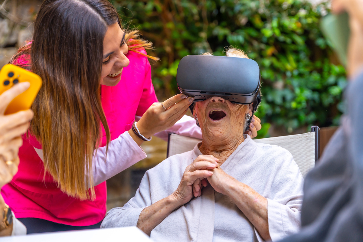 Seniorka si pomocí virtuální reality prohlíží vzdálená místa během terapeutického programu pro pacienty s demencí.
