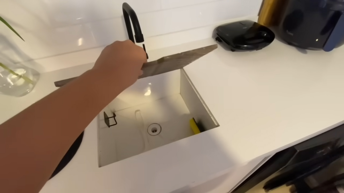 Zakrytý hluboký dřez v kuchyni po zavření funguje jako další pracovní plocha pro vaření.