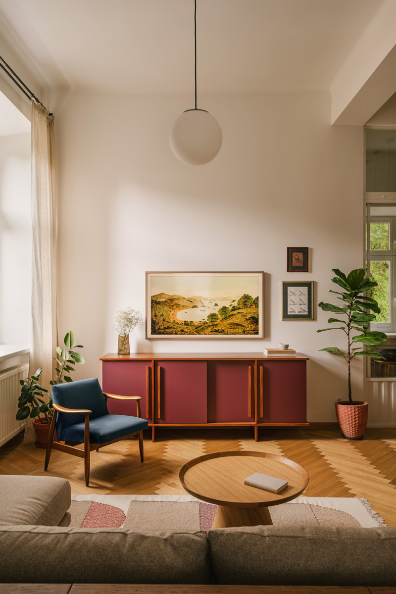 Bordó komoda a modré retro křeslo vnášejí do světlého historického interiéru barevný akcent a osobitou atmosféru.