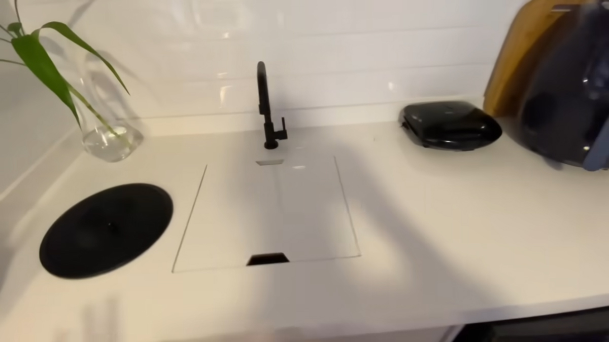 Zakrytý kuchyňský dřez vytváří po uzavření další pracovní plochu pro vaření v malém bytě.