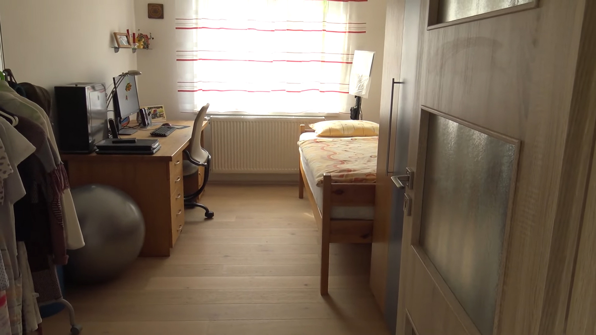 Modernizovaná ložnice kombinuje jednoduchý nábytek a pracovní kout s důrazem na funkčnost a každodenní využití.