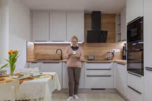 Paní Božena stojí v nové světlé kuchyni, kde si dnes mnohem víc užívá každodenní chvíle i ranní kávu.