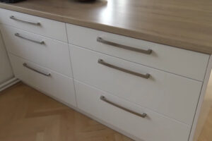 Detail spodních kuchyňských zásuvek s plnovýsuvným systémem ukazuje důraz na ergonomii a praktičnost.