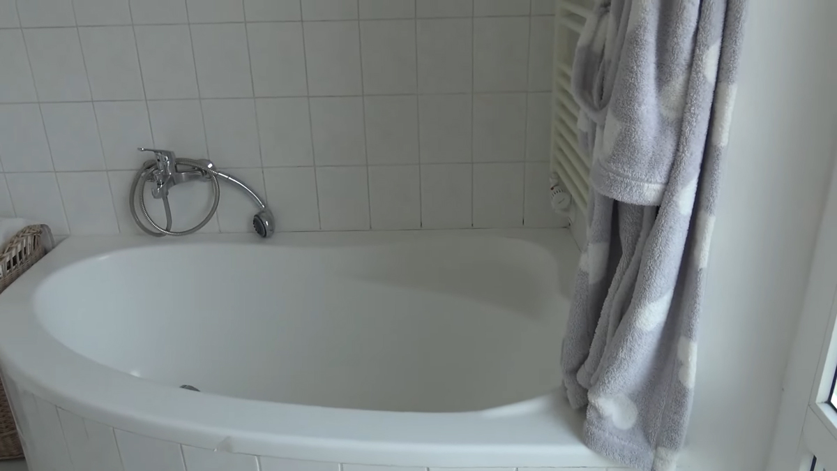Rohová vana v koupelně s původními obklady ukazuje starší řešení prostoru bez výrazné modernizace.