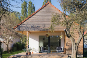 Novostavba se sedlovou střechou a dřevěným obkladem respektuje tradiční venkovskou architekturu a přirozeně zapadá do okolní zástavby.