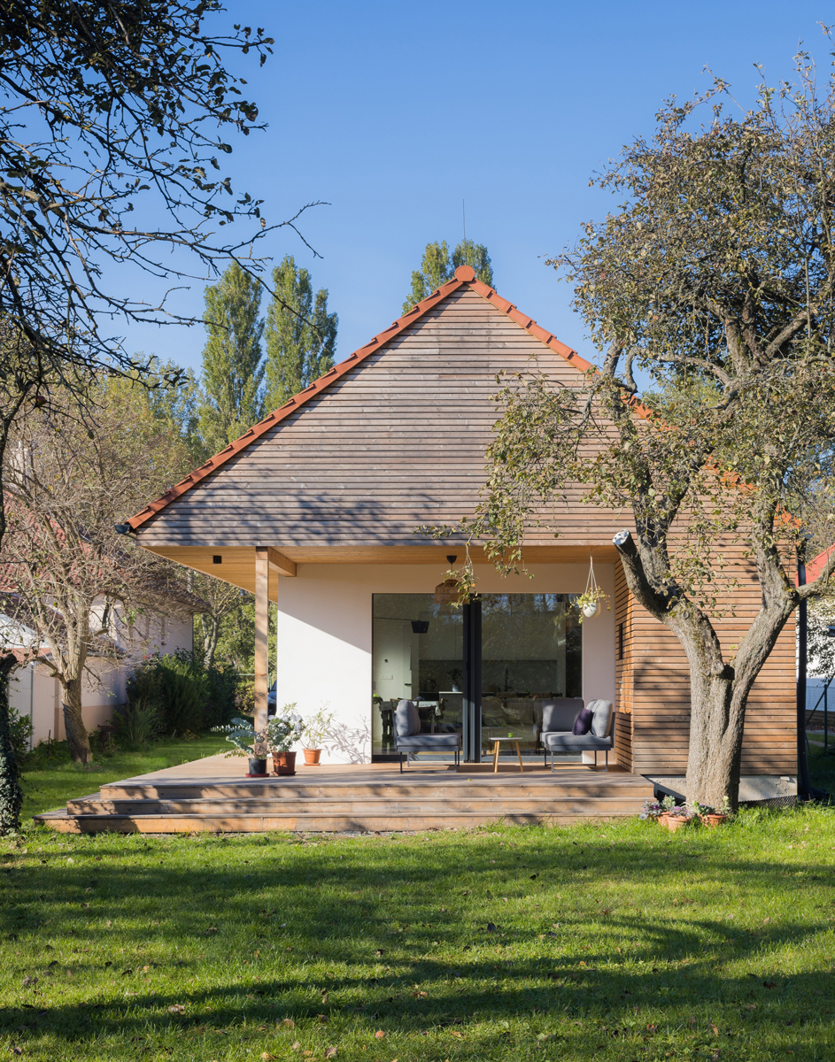 Novostavba se sedlovou střechou a dřevěným obkladem respektuje tradiční venkovskou architekturu a přirozeně zapadá do okolní zástavby.