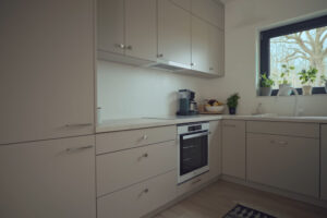 Minimalistická kuchyňská linka nabízí dostatek úložného prostoru a navazuje na celkově střídmý charakter interiéru.