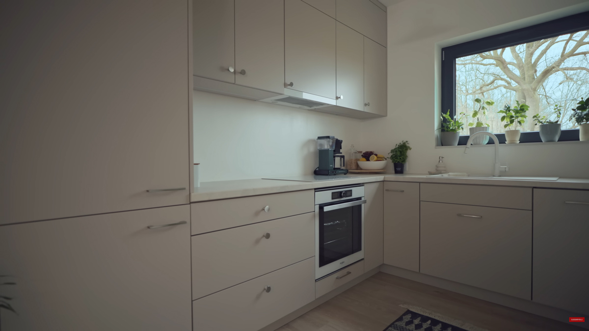 Minimalistická kuchyňská linka nabízí dostatek úložného prostoru a navazuje na celkově střídmý charakter interiéru.
