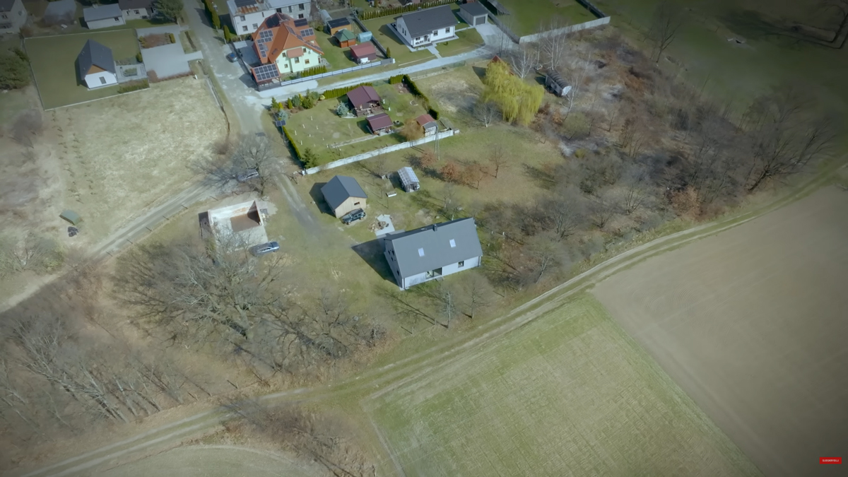 Letecký pohled ukazuje polohu domu na rozlehlém pozemku obklopeném loukami, stromy a volnou krajinou.