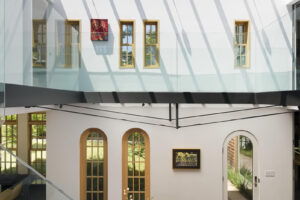 Prosklená galerie s ocelovým mostem propojuje jednotlivá podlaží a současně zachovává otevřenost hlavního obytného prostoru.