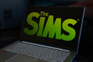 Logo hry The Sims na obrazovce notebooku připomíná jeden z nejúspěšnějších simulátorů života a bydlení všech dob.