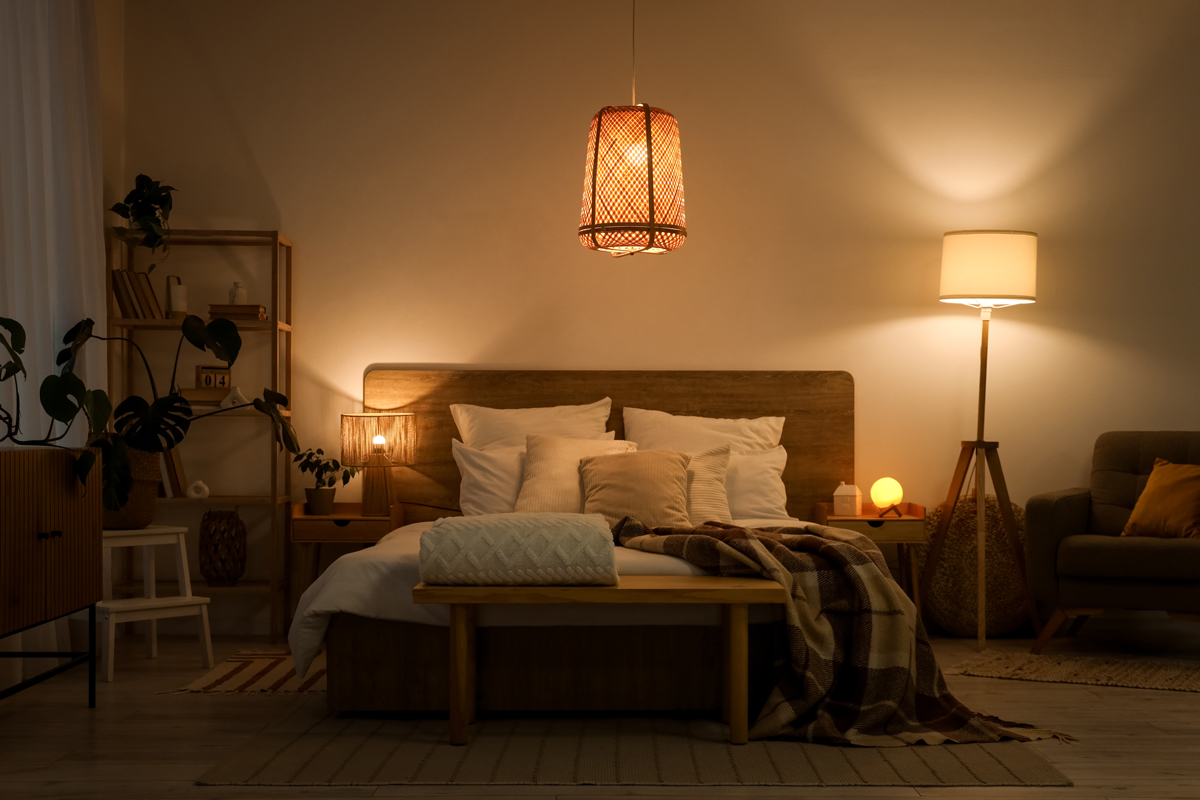 Kombinace stolních lamp a teplého ambientního osvětlení vytváří v ložnici příjemnou atmosféru vhodnou pro večerní relaxaci.