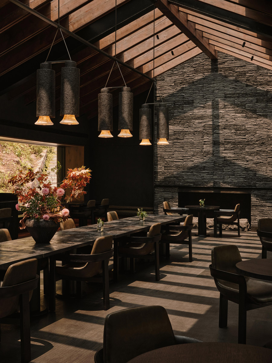 Restaurace s vysokým cedrovým stropem, břidlicovou stěnou a závěsnými svítidly z přírodních materiálů.