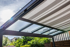 Moderní pergola s posuvným zastíněním chrání terasu před přímým sluncem a zvyšuje komfort venkovního posezení.