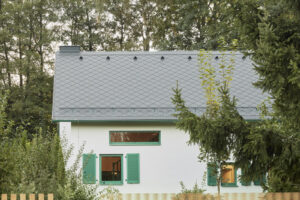 Jednoduchá architektura domu se sedlovou střechou respektuje původní podobu stavby a nenápadně zapadá do okolní zeleně.