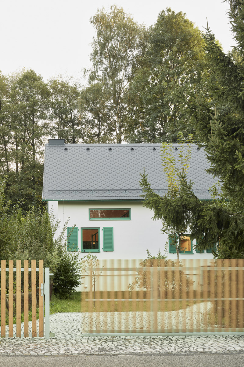 Jednoduchá architektura domu se sedlovou střechou respektuje původní podobu stavby a nenápadně zapadá do okolní zeleně.