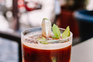 Espresso tonic s ledem, citronem a čerstvou mátou je osvěžující letní kávový nápoj.