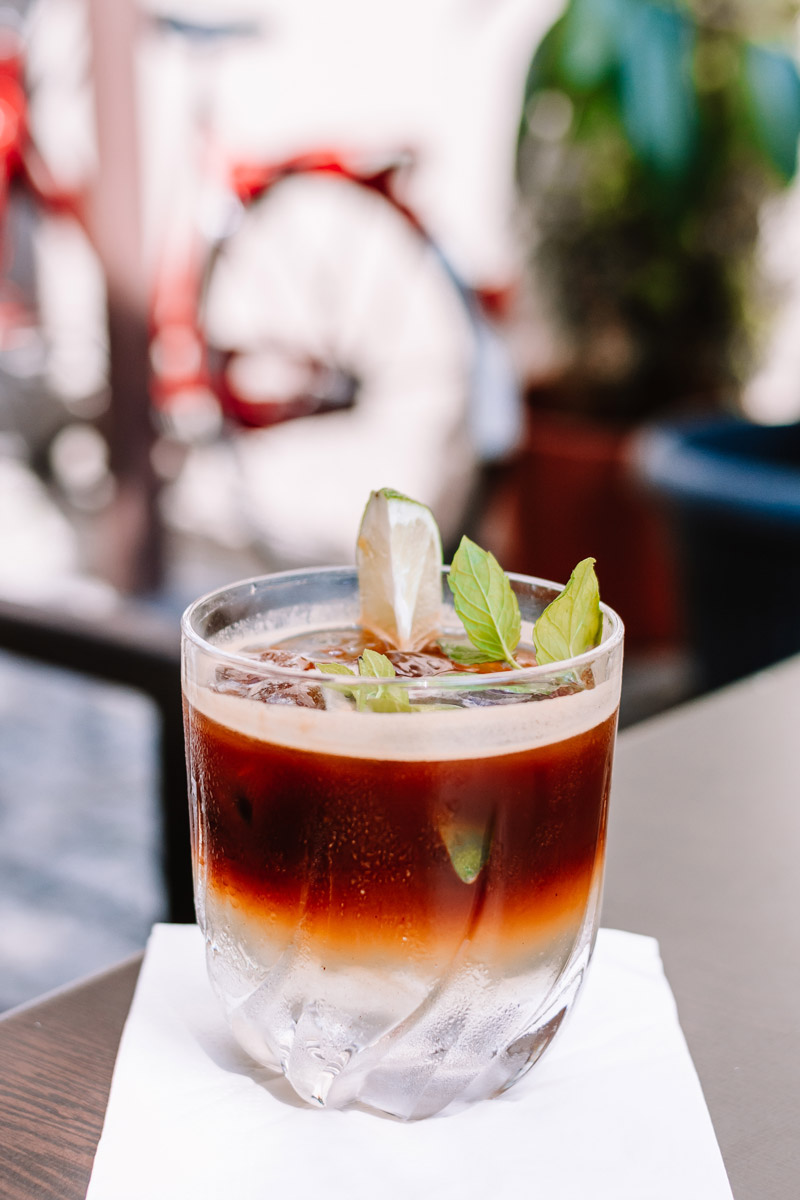 Espresso tonic s ledem, citronem a čerstvou mátou je osvěžující letní kávový nápoj.