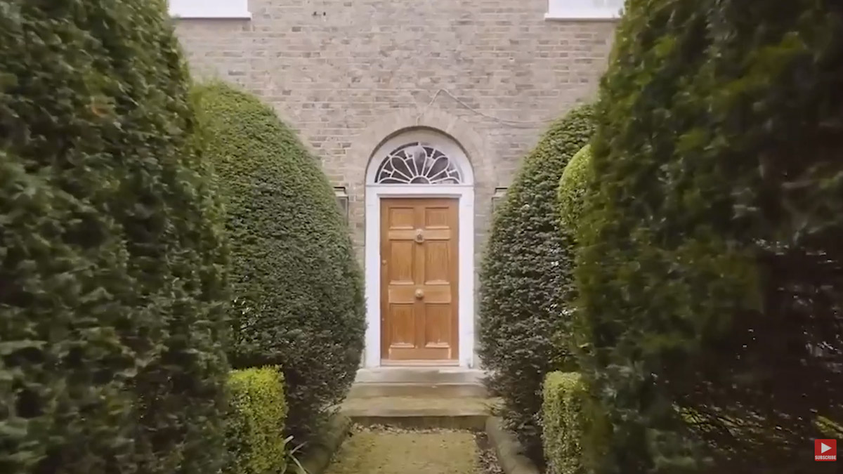 Hlavní vstup do rezidence Garden Lodge vede mezi vysokými živými ploty.