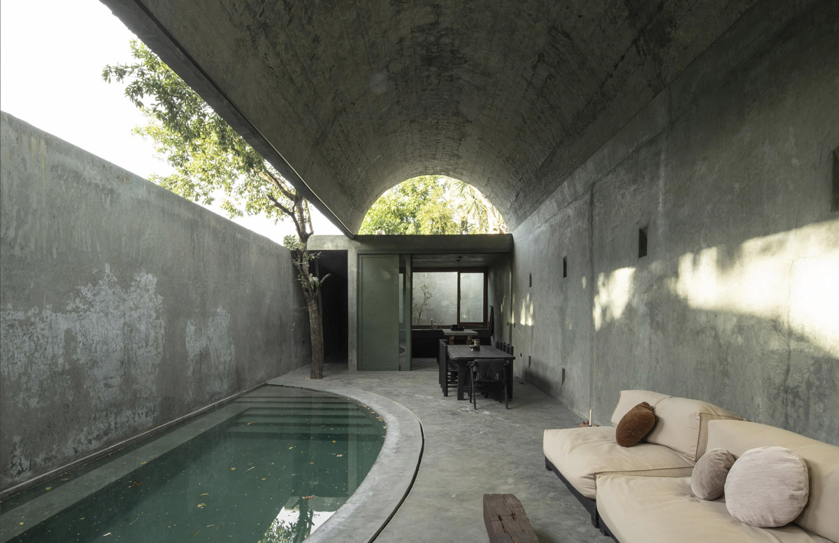 Protáhlý bazén pod betonovou klenbou v otevřené relaxační části domu Casa Gruta.