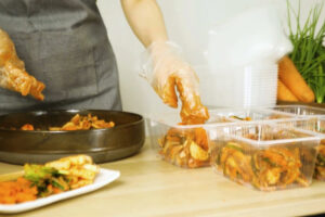 Hotové kimchi se porcuje do menších nádob pro další uchování a konzumaci.