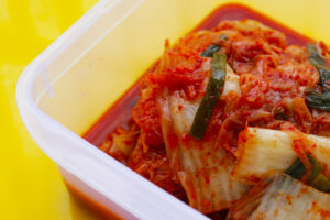 Hotové kimchi z čínského zelí s chilli a jarní cibulkou připravené k fermentaci.