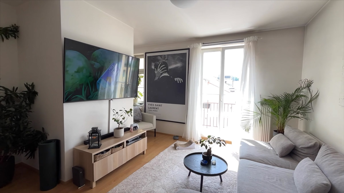 Světlý obývací pokoj propojený s kuchyní nabízí velkou pohovku, televizi i vstup na balkon.