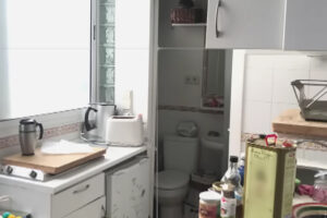 Původní kuchyň a vstup do malé koupelny před rekonstrukcí madridského bytu o rozloze 16 metrů čtverečních.