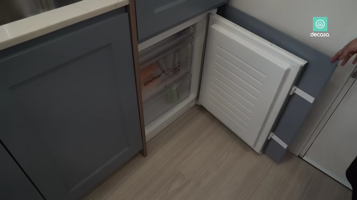 Malý mrazák zabudovaný do spodní části kuchyňské linky v madridském minibytě.