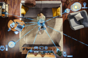 Pohled shora na ženu ovládající chytrou domácnost mobilním telefonem, kolem níž jsou graficky znázorněny propojené spotřebiče a elektronická zařízení.