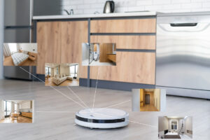 Bílý robotický vysavač na podlaze kuchyně s grafickým znázorněním mapování jednotlivých místností bytu.